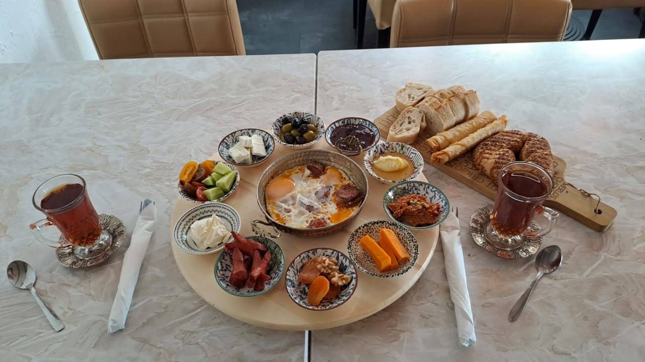 Waffleicious Turkish breakfast with a complete round serving board, small bowls, bread board and tea glasses